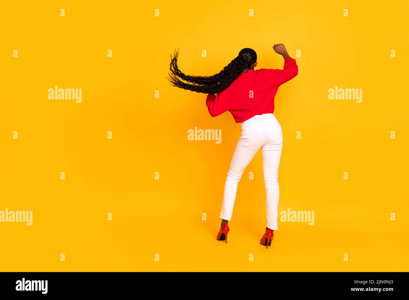Full body back rear view photo of young excited woman dance hang-out clubber isolated over yellow color background Stock Photo