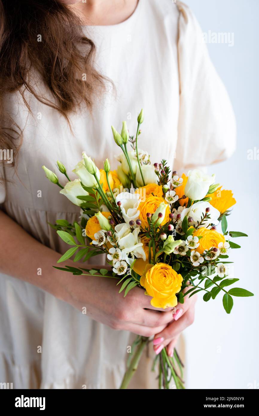 Beautiful woman with spring yellow bouquet of flowers spring and beauty concept Stock Photo