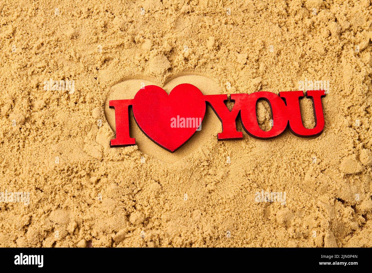 Honeymoon vacation or valentines day concept. Red I love you words on the sand. Stock Photo