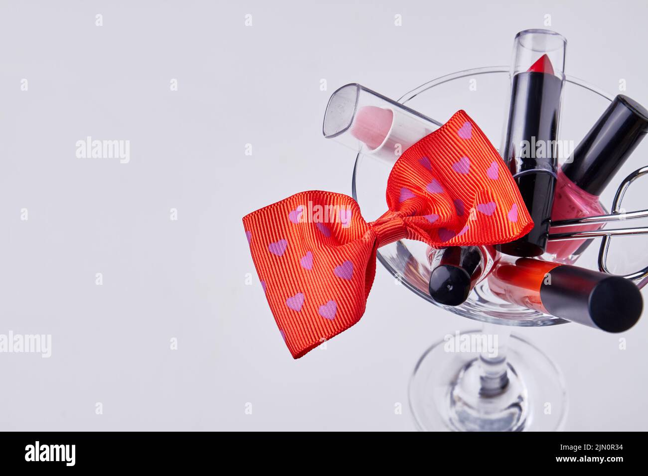 Close up makeup accessories and red bow tie. Isolated on white background. Stock Photo