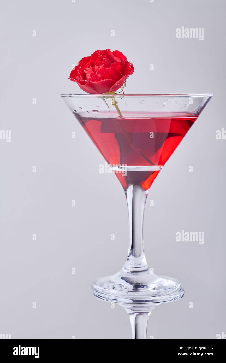 Vertical shot red cocktail with rose flower. Isolated on white background. Stock Photo