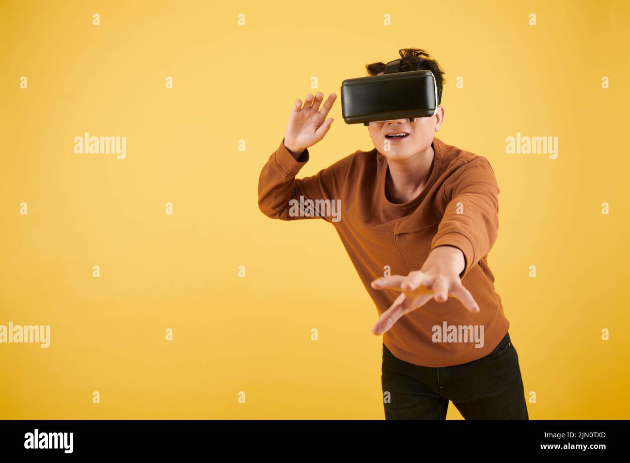Excited young man catching ball in virtual reality game Stock Photo Alamy