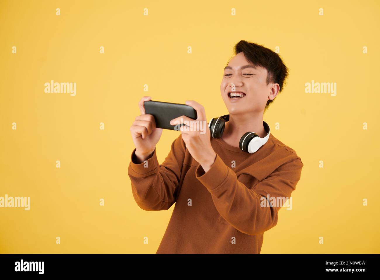 Happy excited young man playing videogame on smartphone Stock Photo