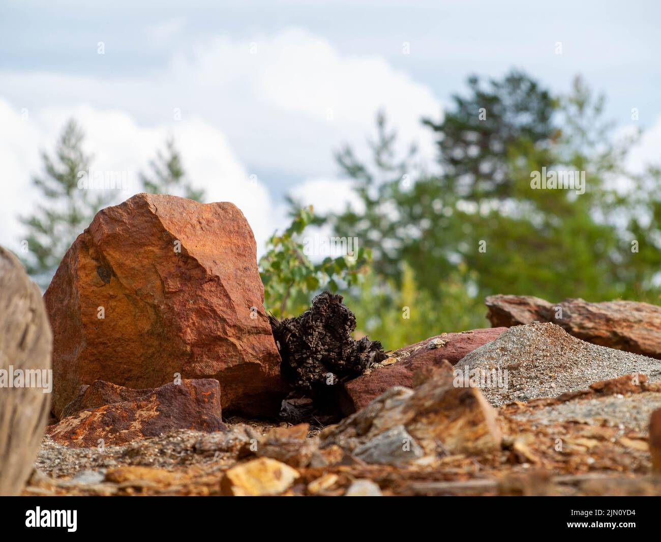 Stone in focus with mountain of slag from Falun Copper Mine World