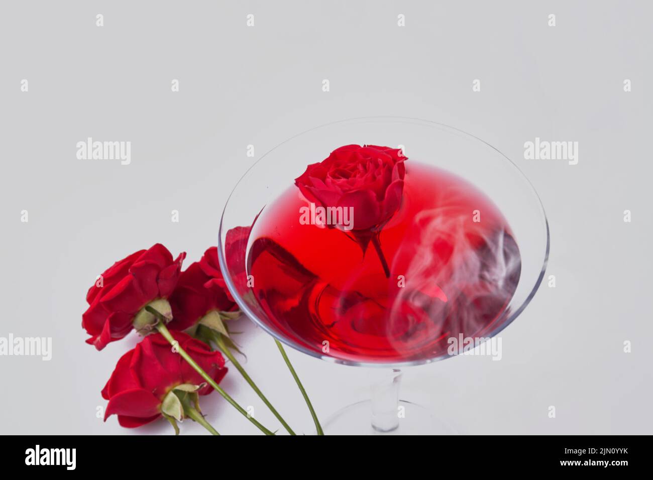 Close up red cocktail and rose flowers. Isolated on white background. Stock Photo