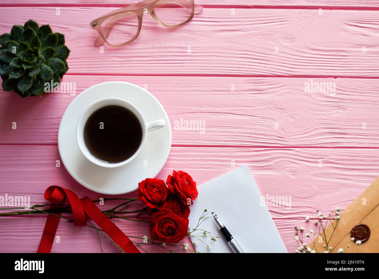 Top view coffee cup with glasses and copy space. Pink wooden desk background. Stock Photo