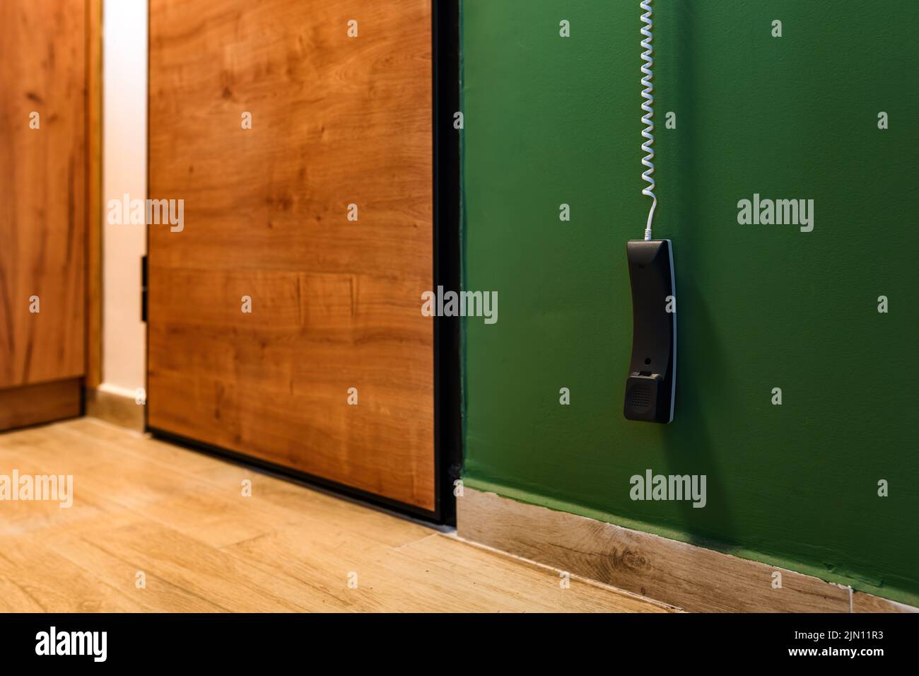 Apartment intercom phone hanging by the entrance door, selective focus Stock Photo