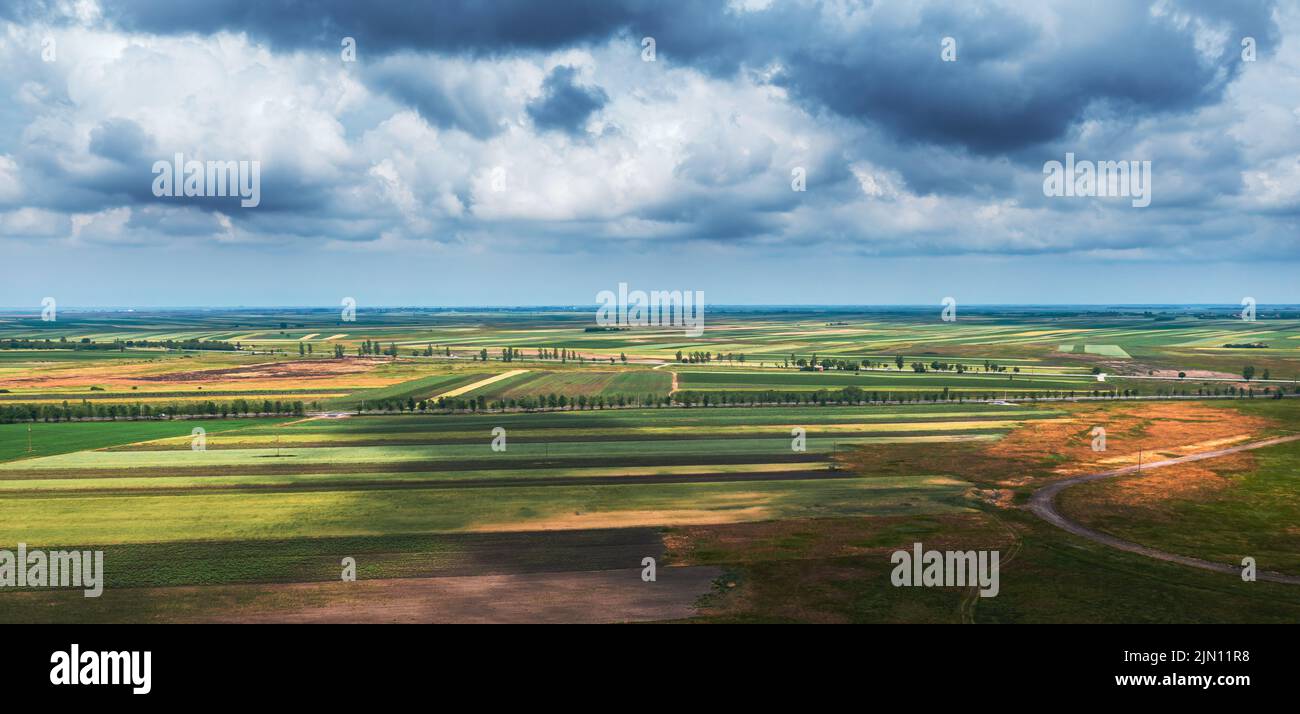 Aerial shot of beautiful countryside landscape with cultivated fields in Banat, geographical region of Vojvodina province in Serbia, drone pov high an Stock Photo