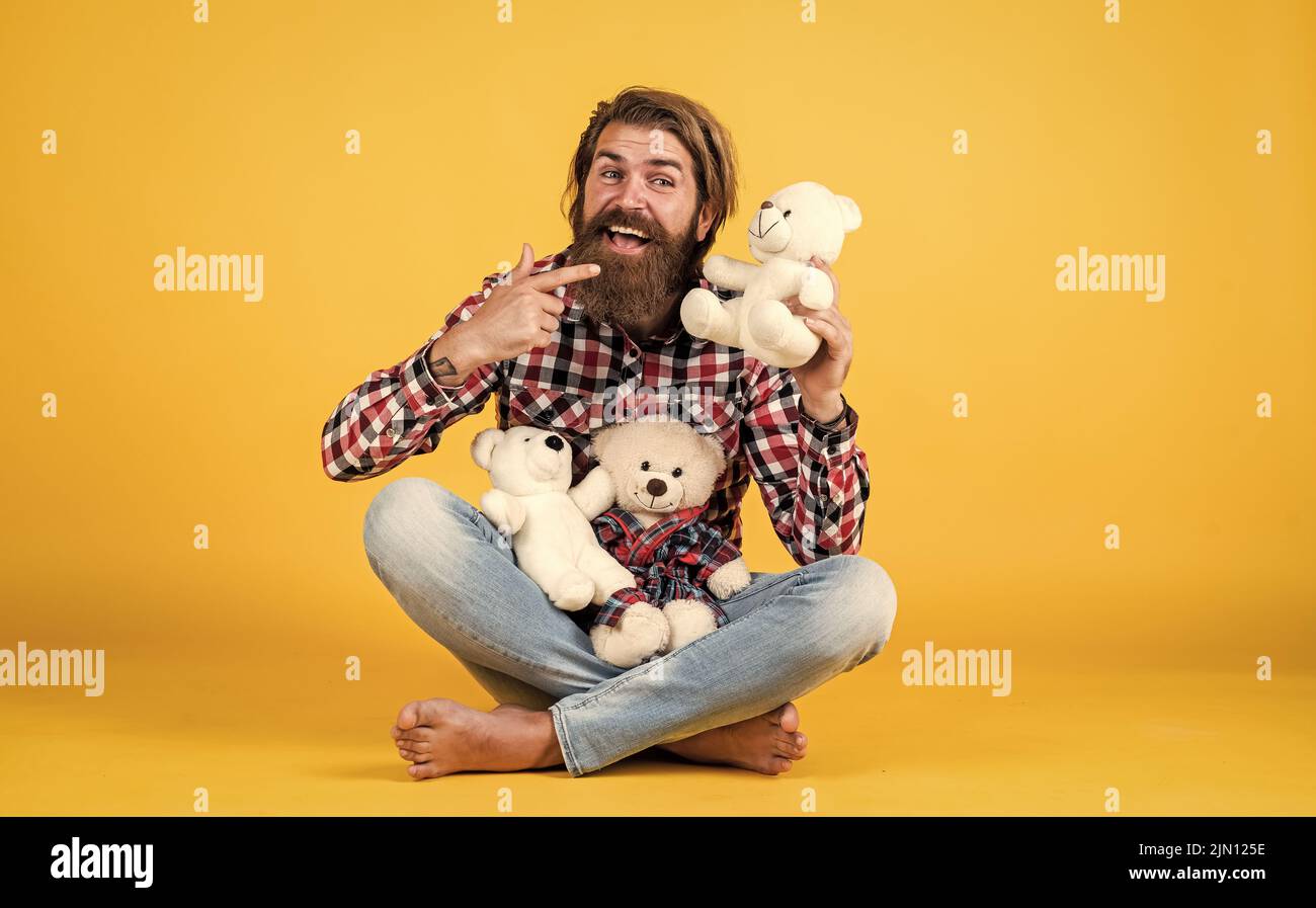 what a cute. cheerful bearded man hold teddy bear. male feel playful with bear. brutal mature hipster man play with toy. happy birthday. being in good Stock Photo