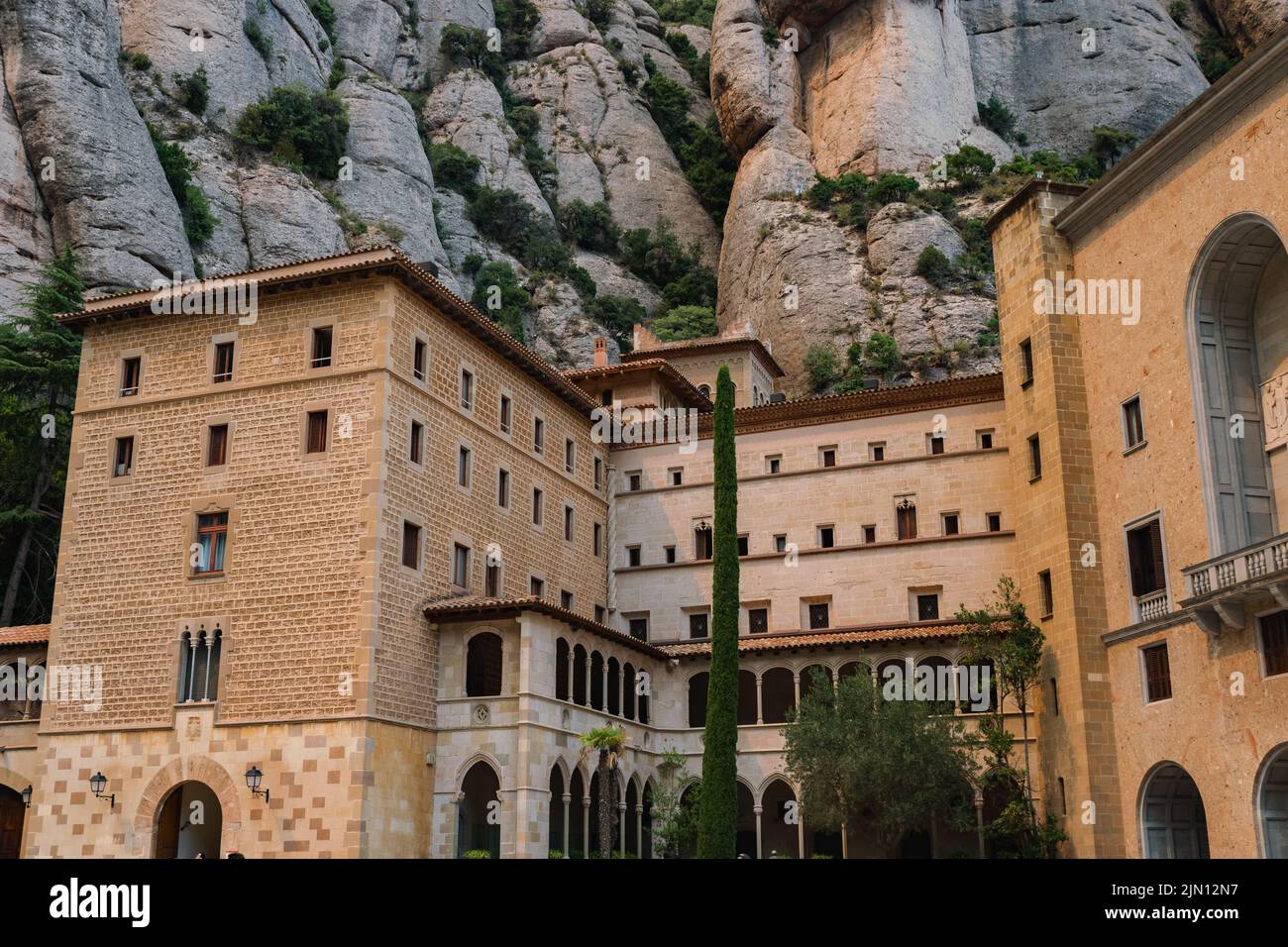Horizontal shot of monastery buildings in Montserrat, Spain in front of a rocky mountain Stock Photo