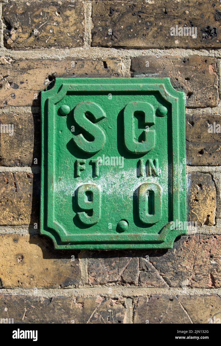 british wall sign indicating the location of a stopcock, for controlling mains water, at a distance of 9 feet, in brentford, london, england Stock Photo