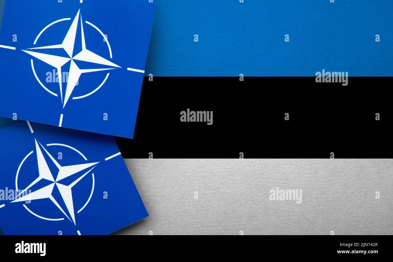 LONDON, UK - August 2022: NATO North Atlantic Treaty Organization military alliance logo on a Estonia flag Stock Photo