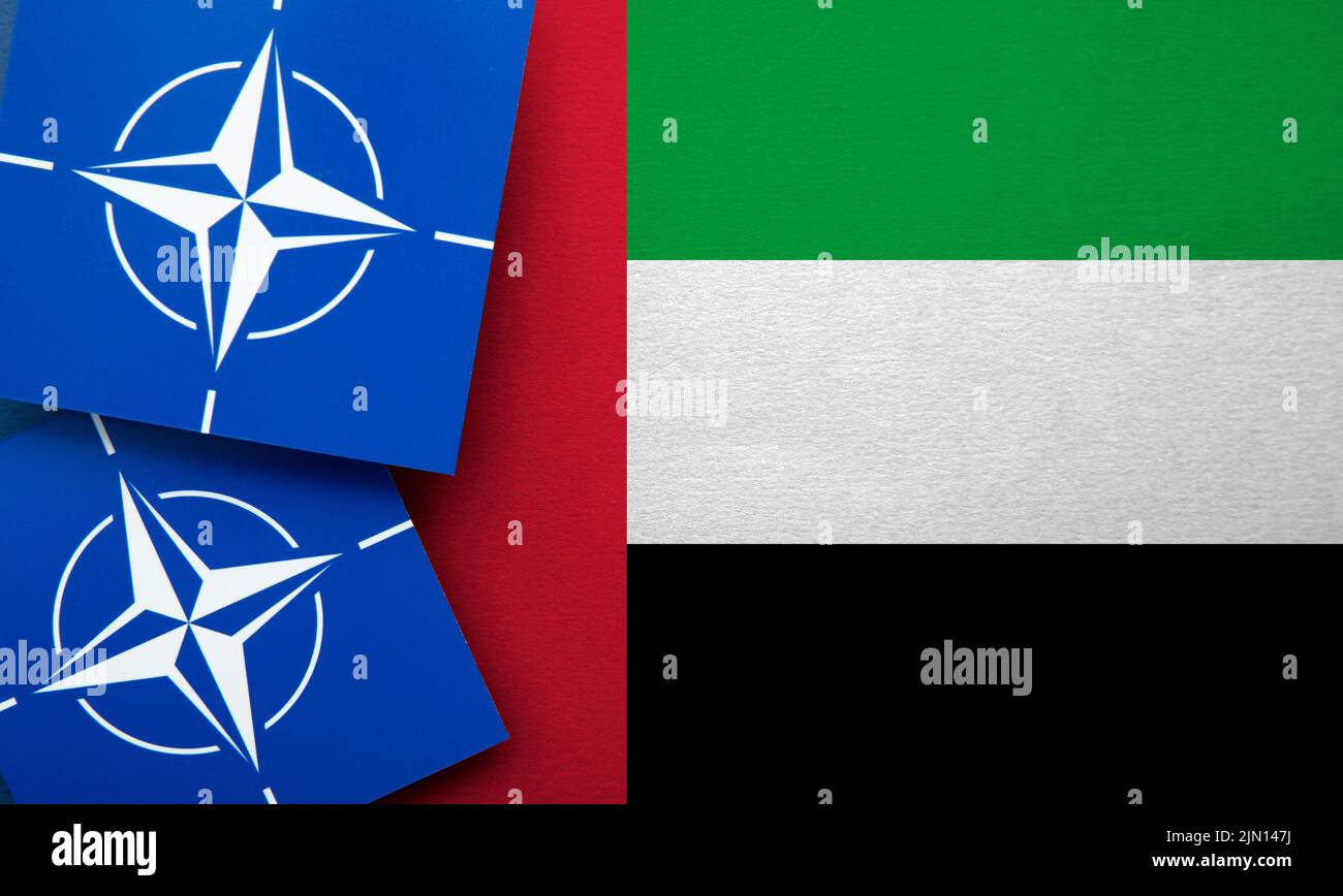 LONDON, UK - August 2022: NATO North Atlantic Treaty Organization military alliance logo on a UAE flag Stock Photo