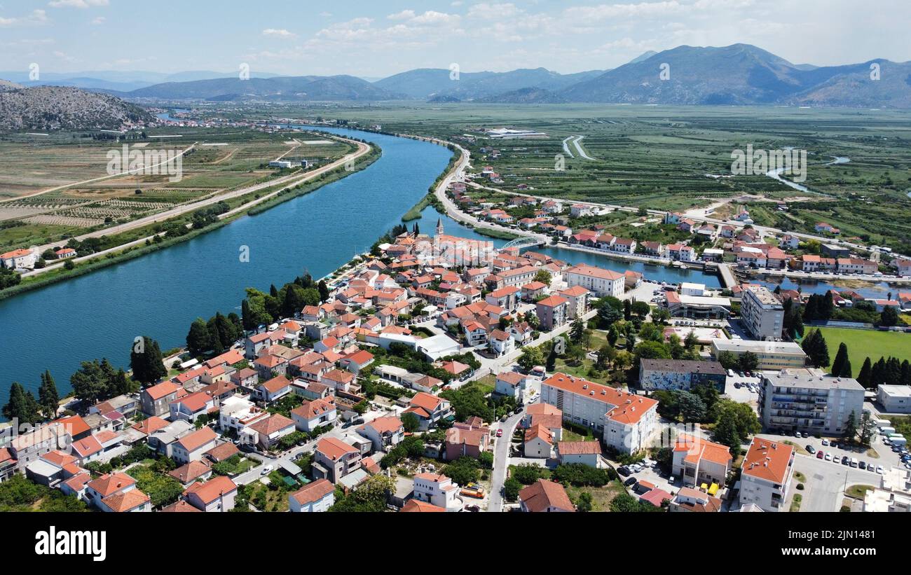 The aerial view of the town and river surrounded by green fields and ...