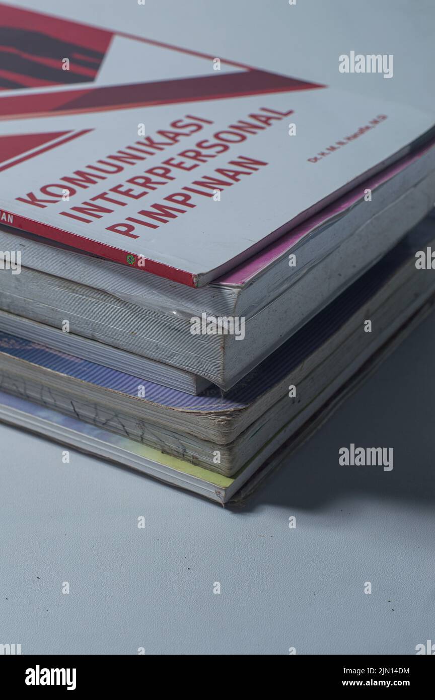 A vertical closeup shot of textbooks on the table, translation: leadership interpersonal communication Stock Photo