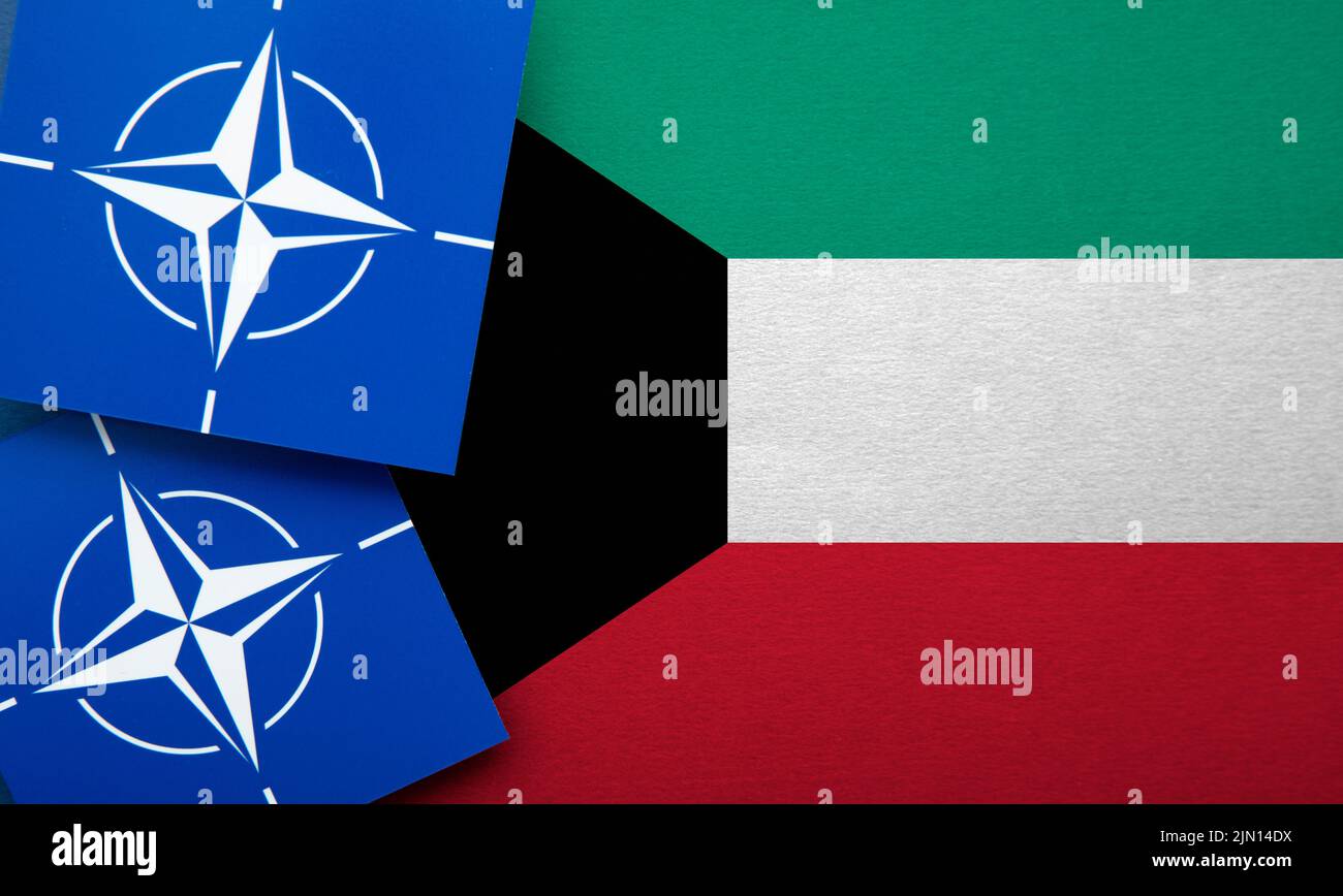 LONDON, UK - August 2022: NATO North Atlantic Treaty Organization military alliance logo on a Kuwait flag Stock Photo
