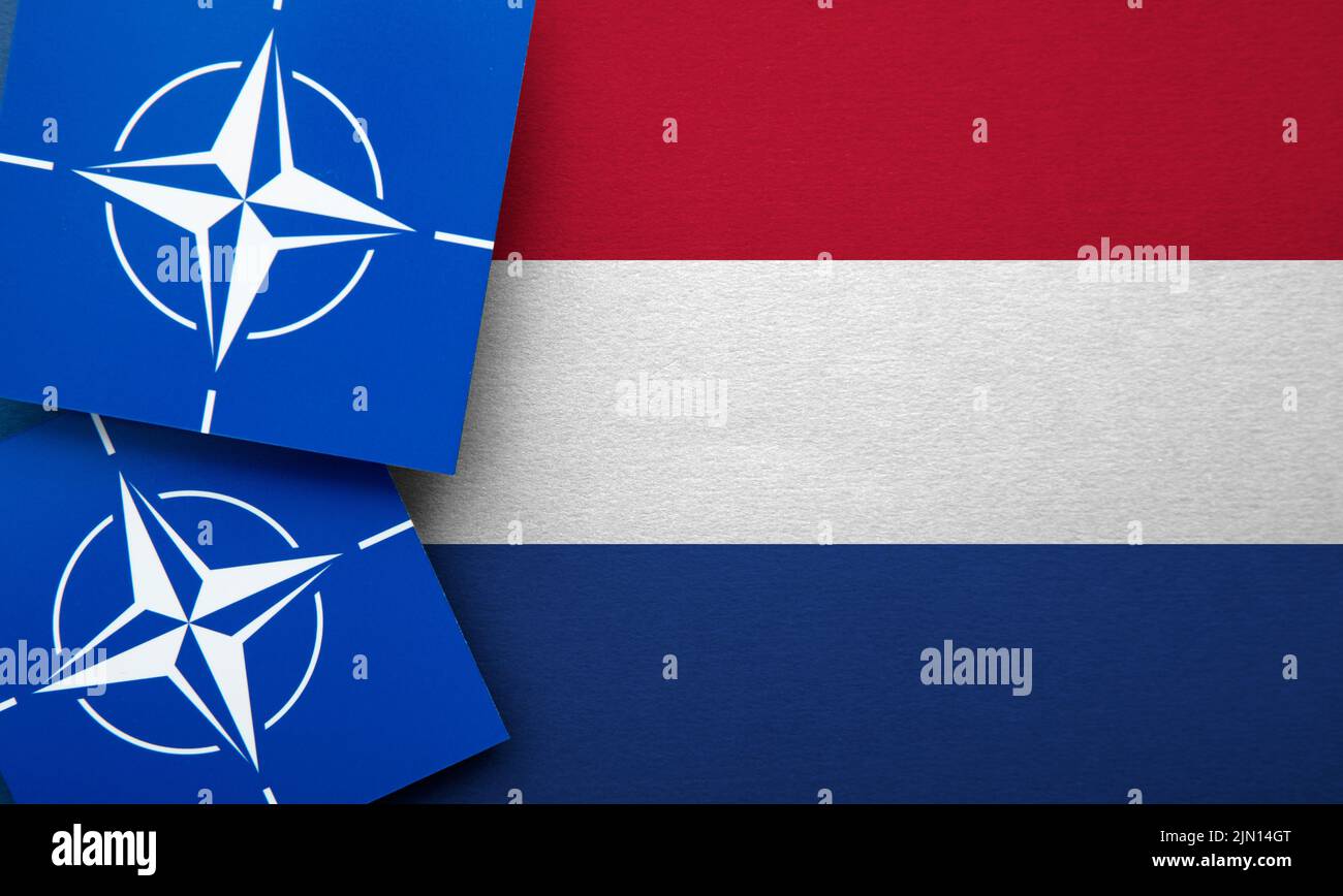 LONDON, UK - August 2022: NATO North Atlantic Treaty Organization military alliance logo on a Netherlands flag Stock Photo