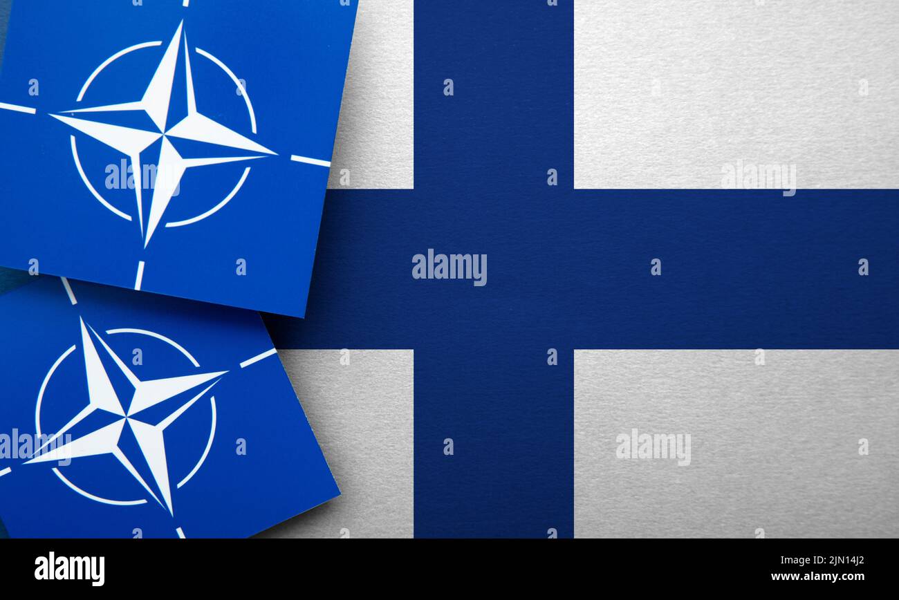 LONDON, UK - August 2022: NATO North Atlantic Treaty Organization military alliance logo on a Finland flag Stock Photo