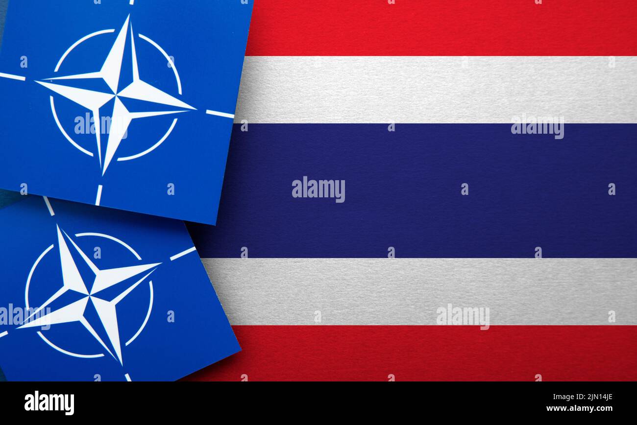 LONDON, UK - August 2022: NATO North Atlantic Treaty Organization military alliance logo on a Thailand flag Stock Photo