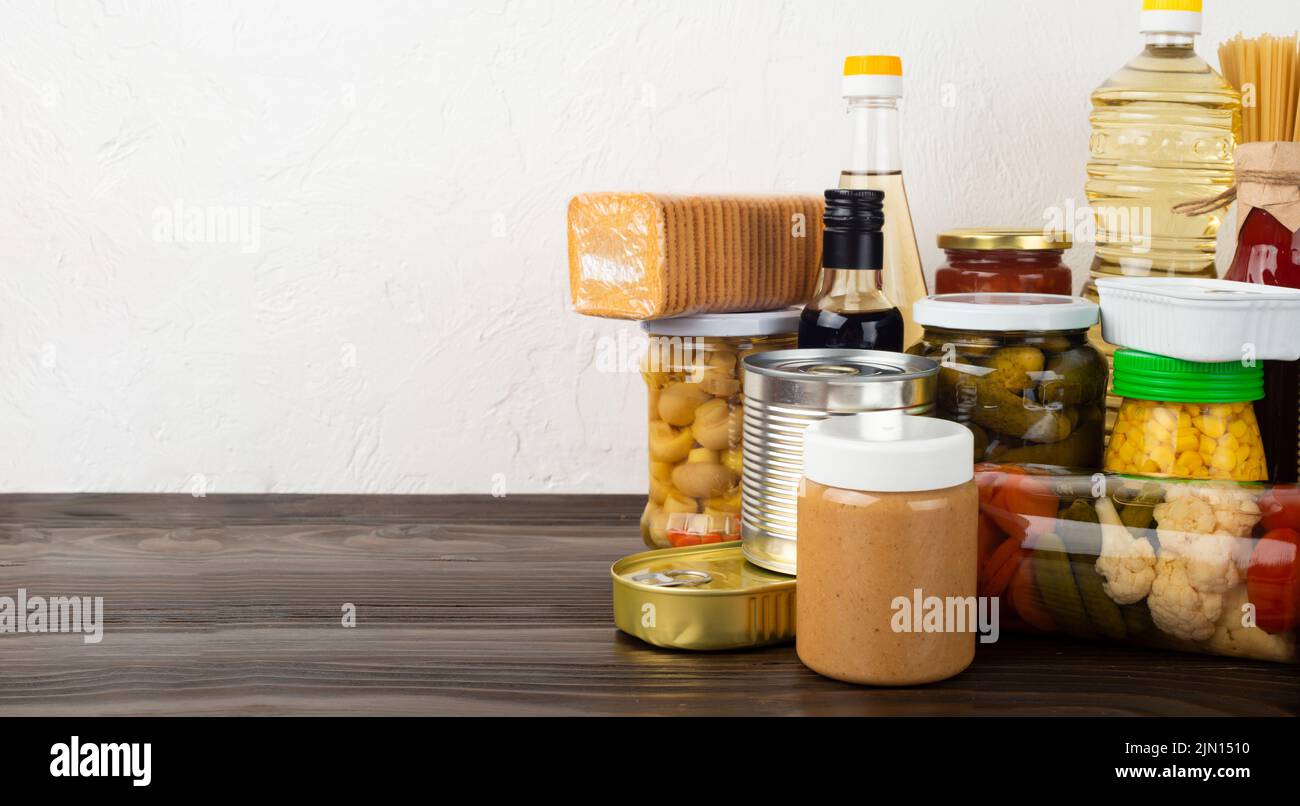 Emergency survival food set on dark wooden kitchen table Stock Photo