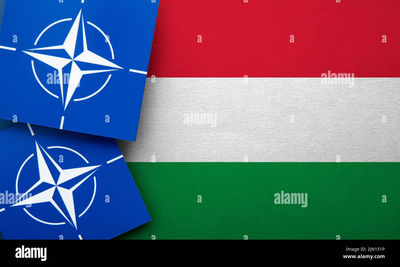 LONDON, UK - August 2022: NATO North Atlantic Treaty Organization military alliance logo on a Hungary flag Stock Photo