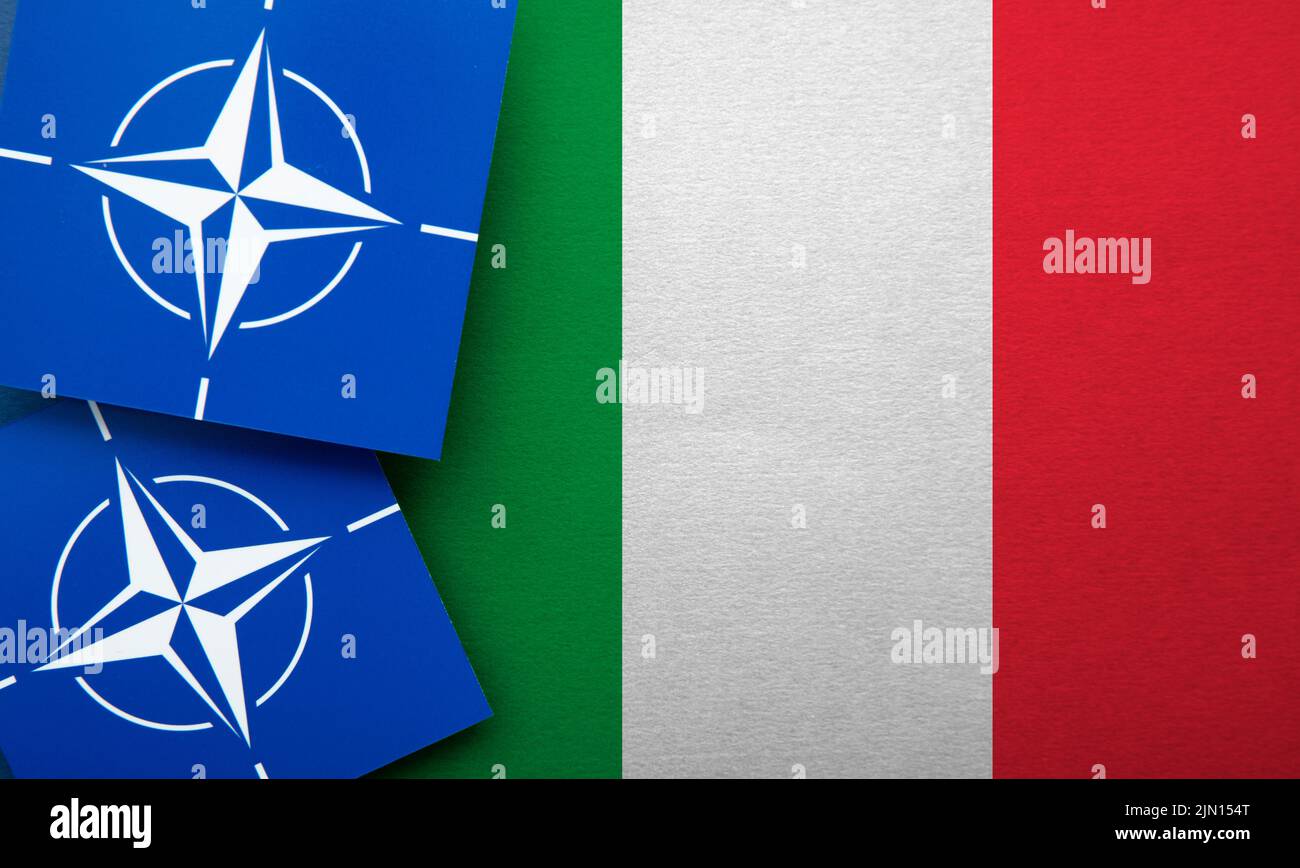 LONDON, UK - August 2022: NATO North Atlantic Treaty Organization military alliance logo on a Italy flag Stock Photo