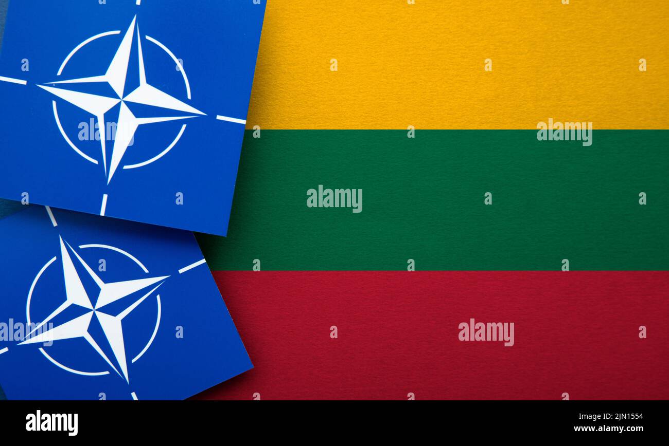 LONDON, UK - August 2022: NATO North Atlantic Treaty Organization military alliance logo on a Lithuania flag Stock Photo
