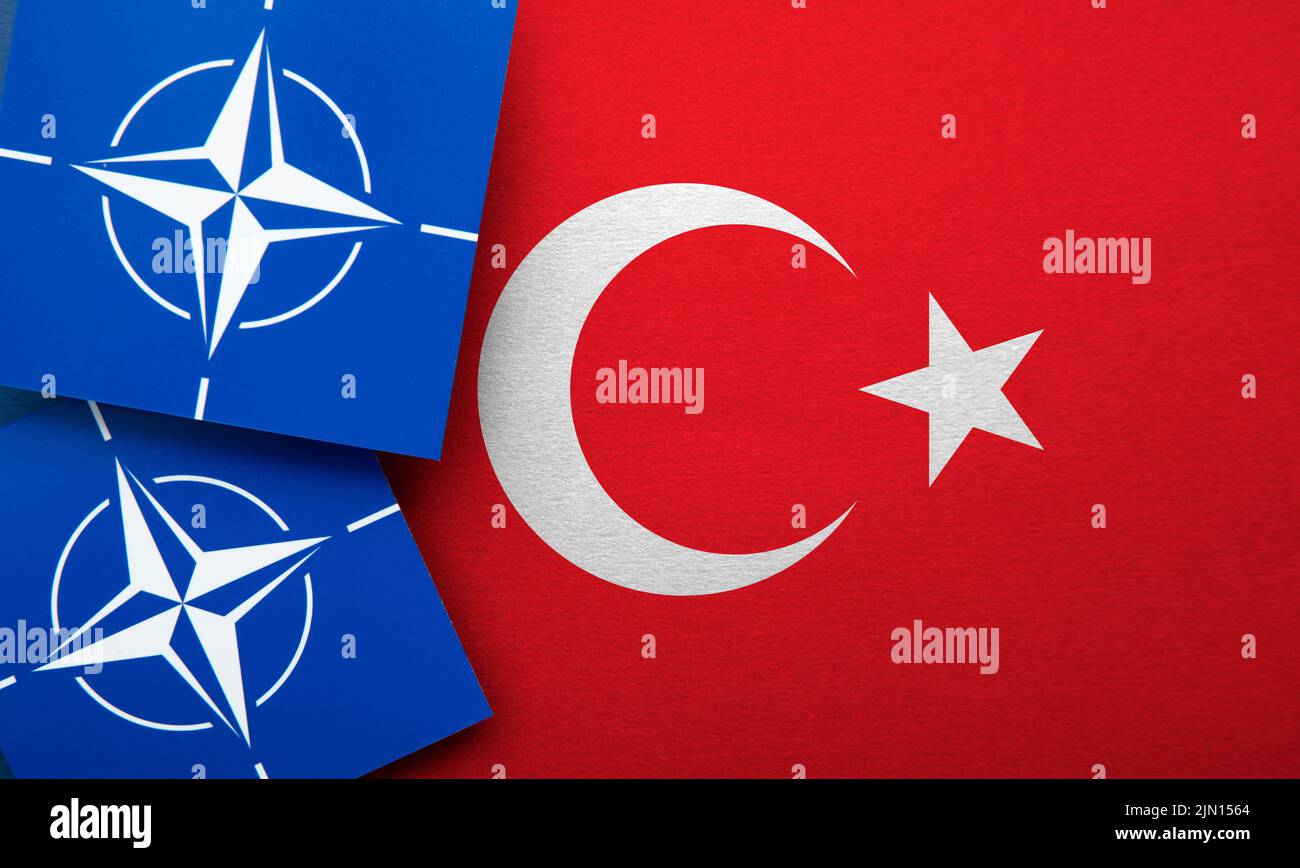 LONDON, UK - August 2022: NATO North Atlantic Treaty Organization military alliance logo on a Turkish flag Stock Photo