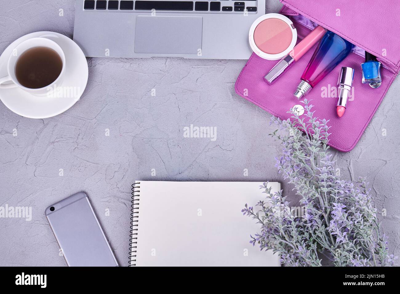 Top view flat lay womans workdesk with copy space. Cup of coffee with laptop and purse. Stock Photo