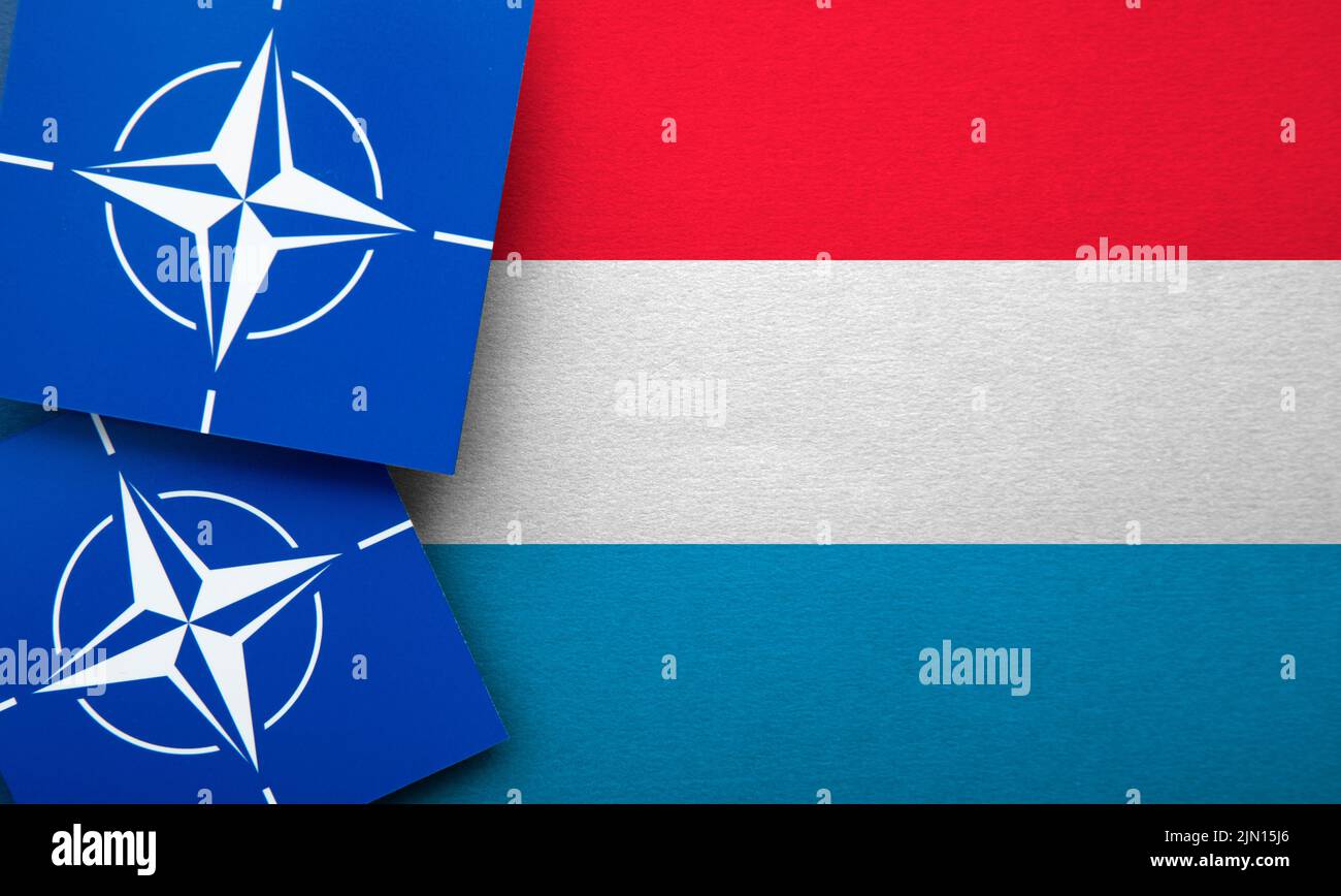 LONDON, UK - August 2022: NATO North Atlantic Treaty Organization military alliance logo on a Luxembourg flag Stock Photo