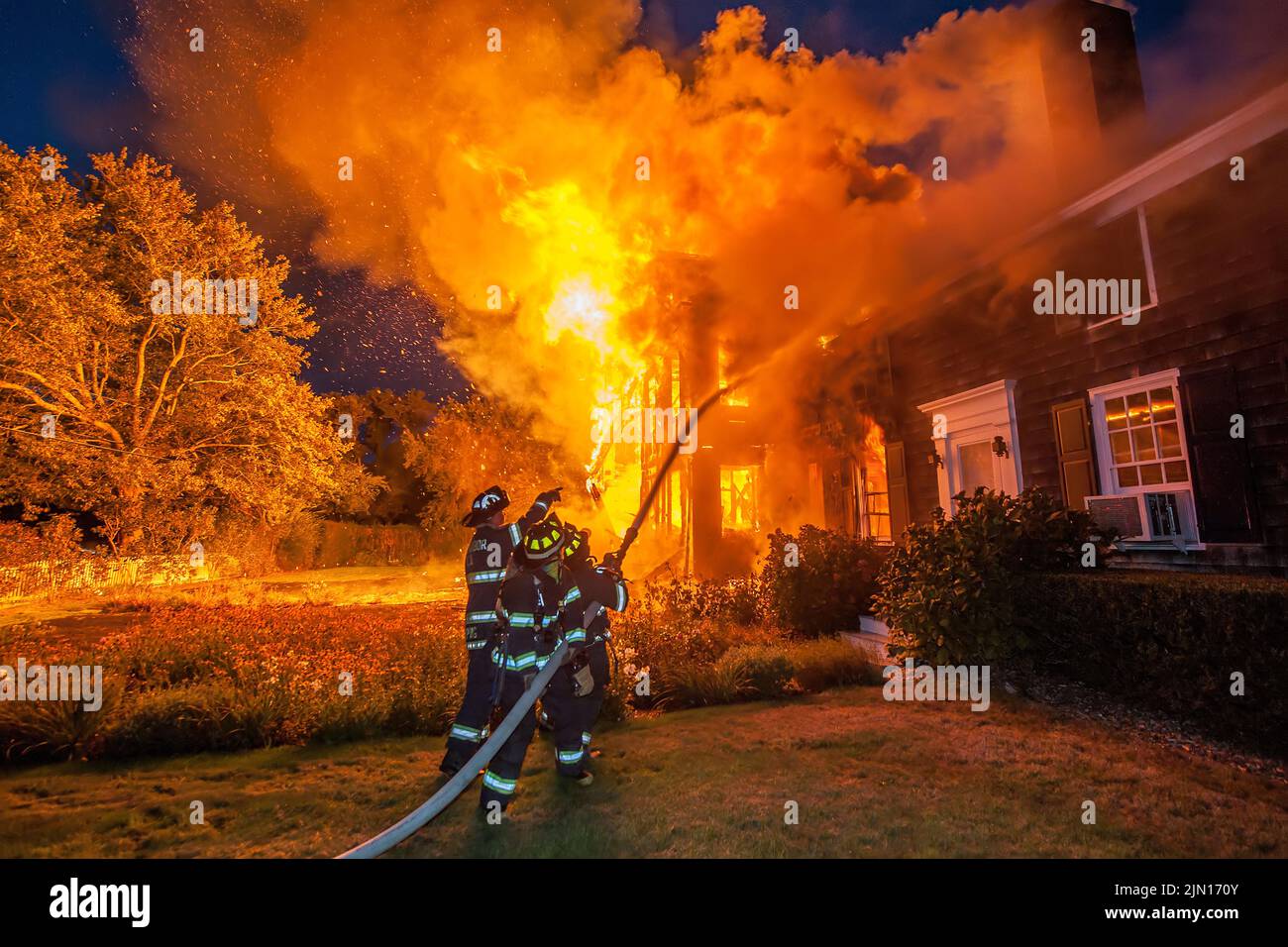A hose team uses a hose to attack the fire as just before 6 a.m. on Monday, September 15th, 2014 the Bridgehampton Fire Department was called to 850 S Stock Photo