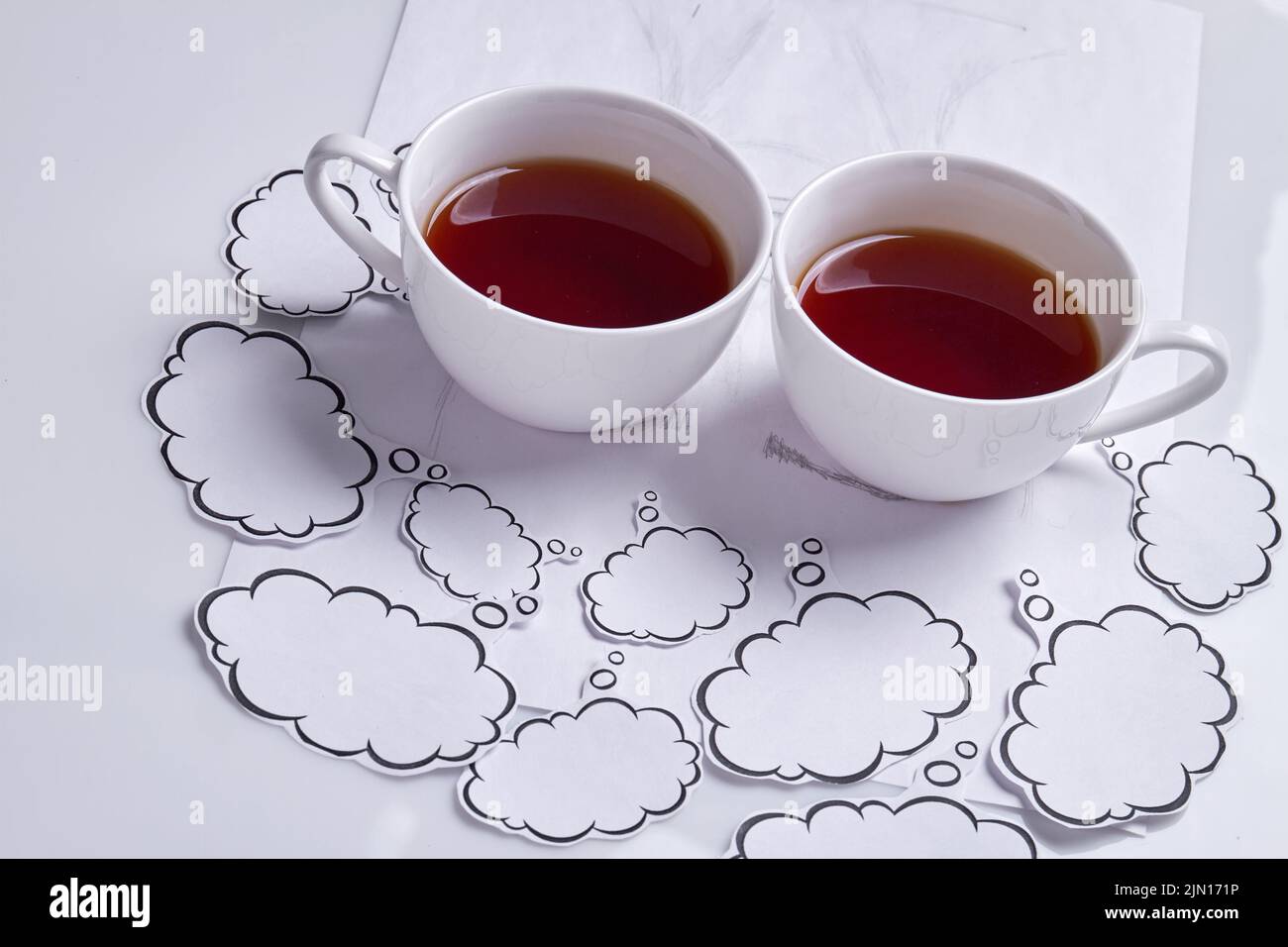Close up two coffee cups with thought bubbles. Isolated on white. Stock Photo