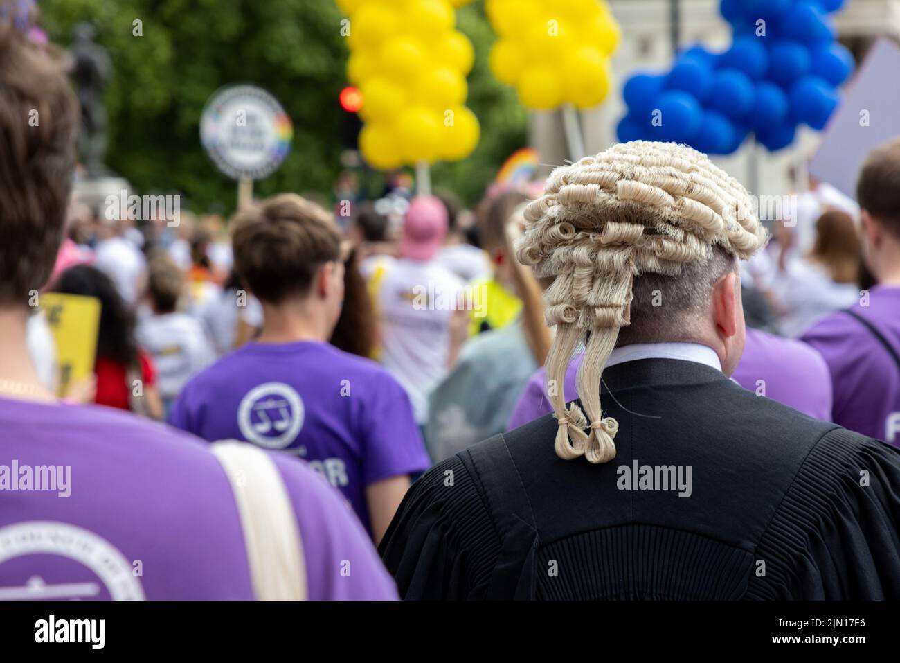A barrister marches as part of the Legal block at  London Pride 2022, dressed in traditional gown and wig. Stock Photo