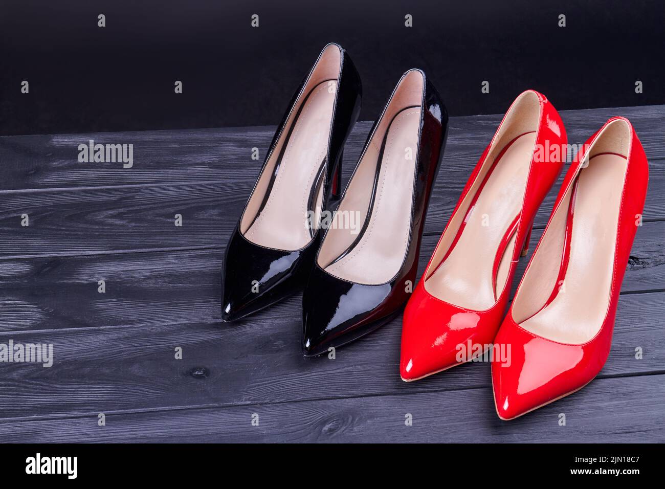 Pair of red and black high heel shoes. Shiny female footwear. Stock Photo