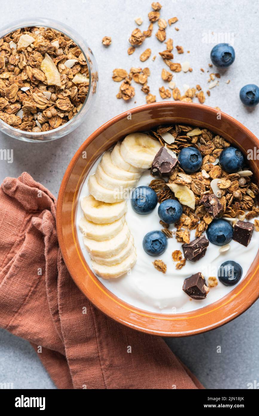 Yogurt granola bowl with blueberries, banana and chocolate. Top view Stock Photo