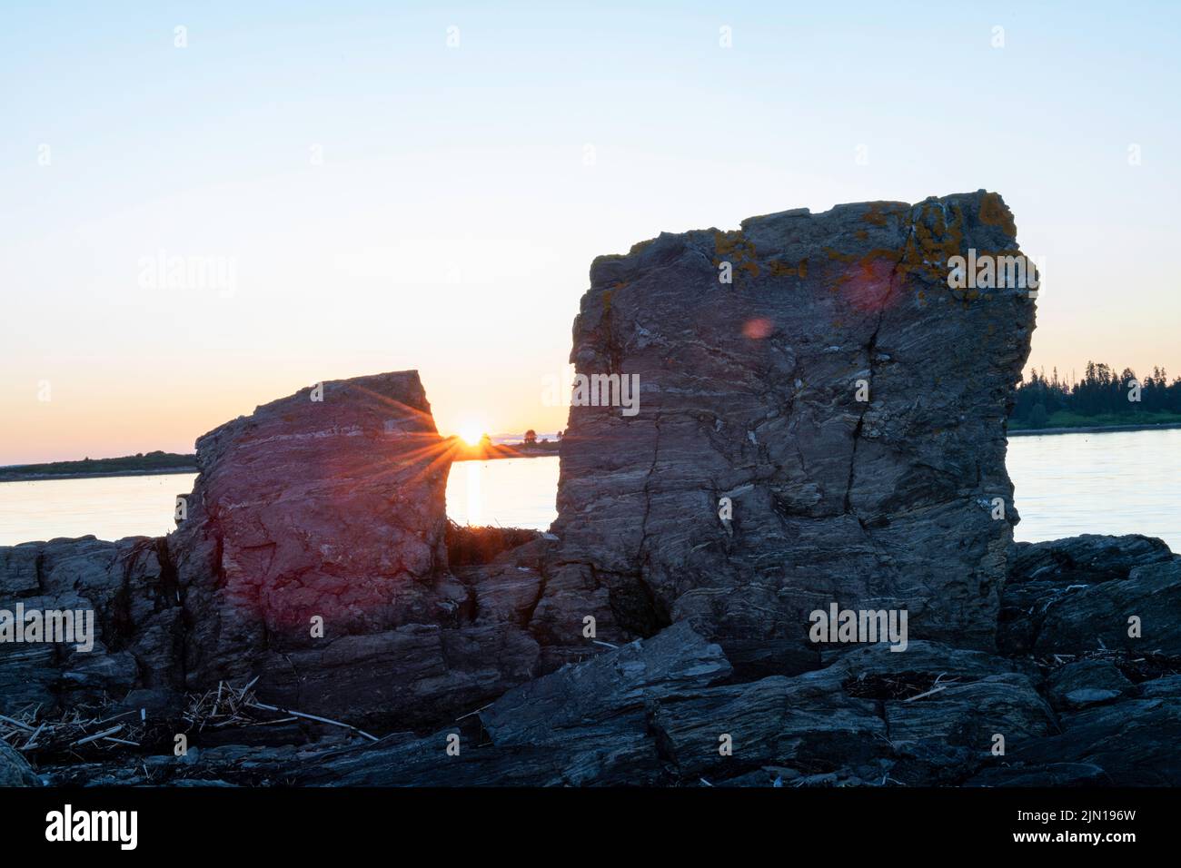 July 6, 2022.  8:16:28 pm.  Two rocks at sunset.  Barnes Island.  Casco Bay, Maine. Stock Photo