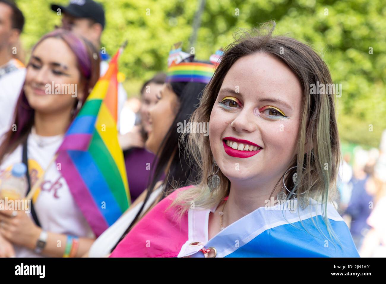 A woman with rainbow make-up around her eyes lines the streets of London, Piccadilly at Pride London 2022. the annual march is a celebration for the l Stock Photo