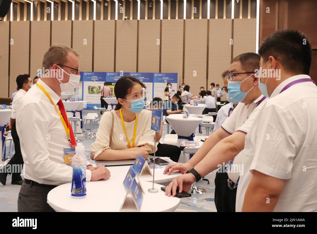 (220808) -- SHANGHAI, Aug. 8, 2022 (Xinhua) -- An exhibitor (2nd L, front) negotiates with potential buyers while attending a pre-expo supply-demand matchmaking meeting for the Intelligent Industry & Information Technology Exhibition Area of the fifth China International Import Expo (CIIE) at the National Exhibition and Convention Center (Shanghai) in east China's Shanghai, Aug. 8, 2022. (Xinhua/Fang Zhe) Stock Photo
