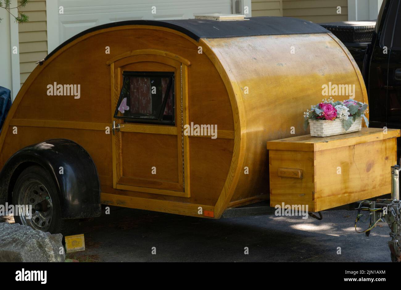 old wooden teardrop trailer in house driveway in Wiscasset Maine Stock Photo