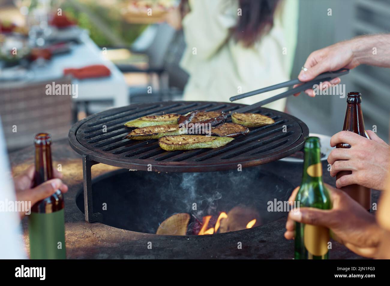 Close up of young people grilling vegetables during barbeque party outdoors in Summer, copy space Stock Photo