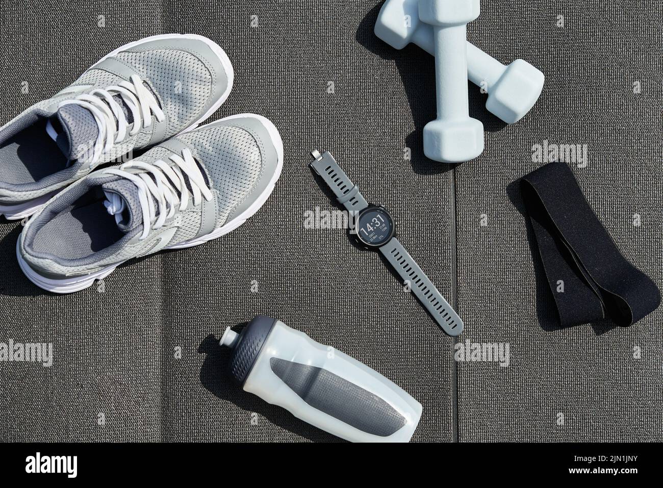 Sport items, fitness smart watches and running sneakers on gray background, Set of objects for workout exercises outdoors, Healthy lifestyle and body Stock Photo