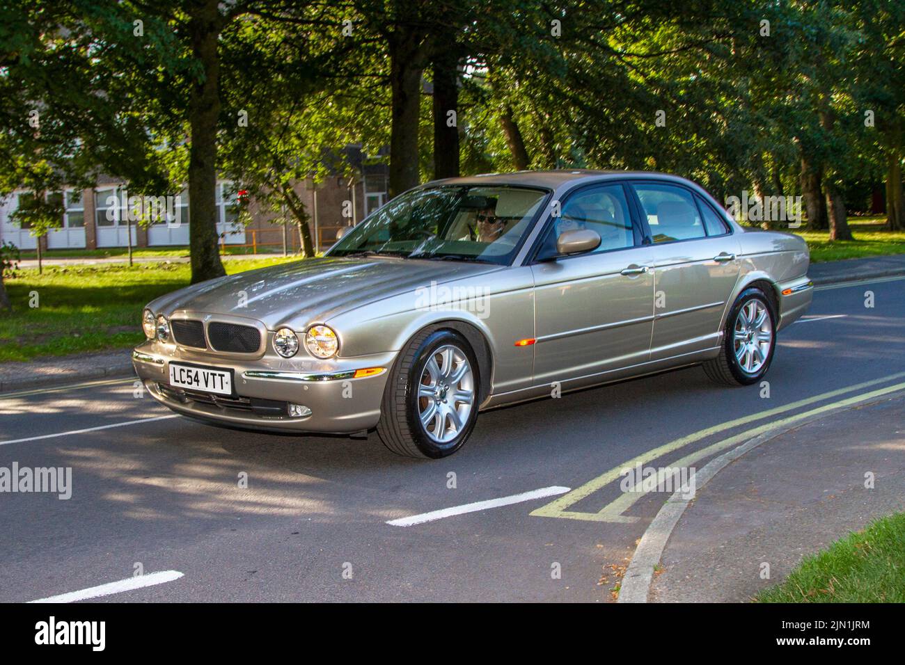 2004 Beige British Jaguar XJ V8 Sport petrol 3555cc 6-speed manual luxury automobile; Collectable cars are travelling to display at the 13th Lytham Hall Summer Classic Car & Motorcycle Show, a Classic Vintage Collectible Transport Festival. Stock Photo
