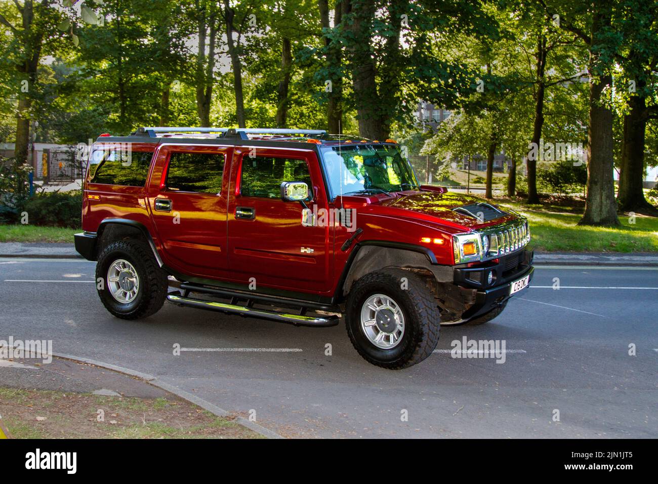 Red HUMMER SUV;  Collectable cars are travelling to display at the 13th Lytham Hall Summer Classic Car & Motorcycle Show, a Classic Vintage Collectible Transport Festival. Stock Photo