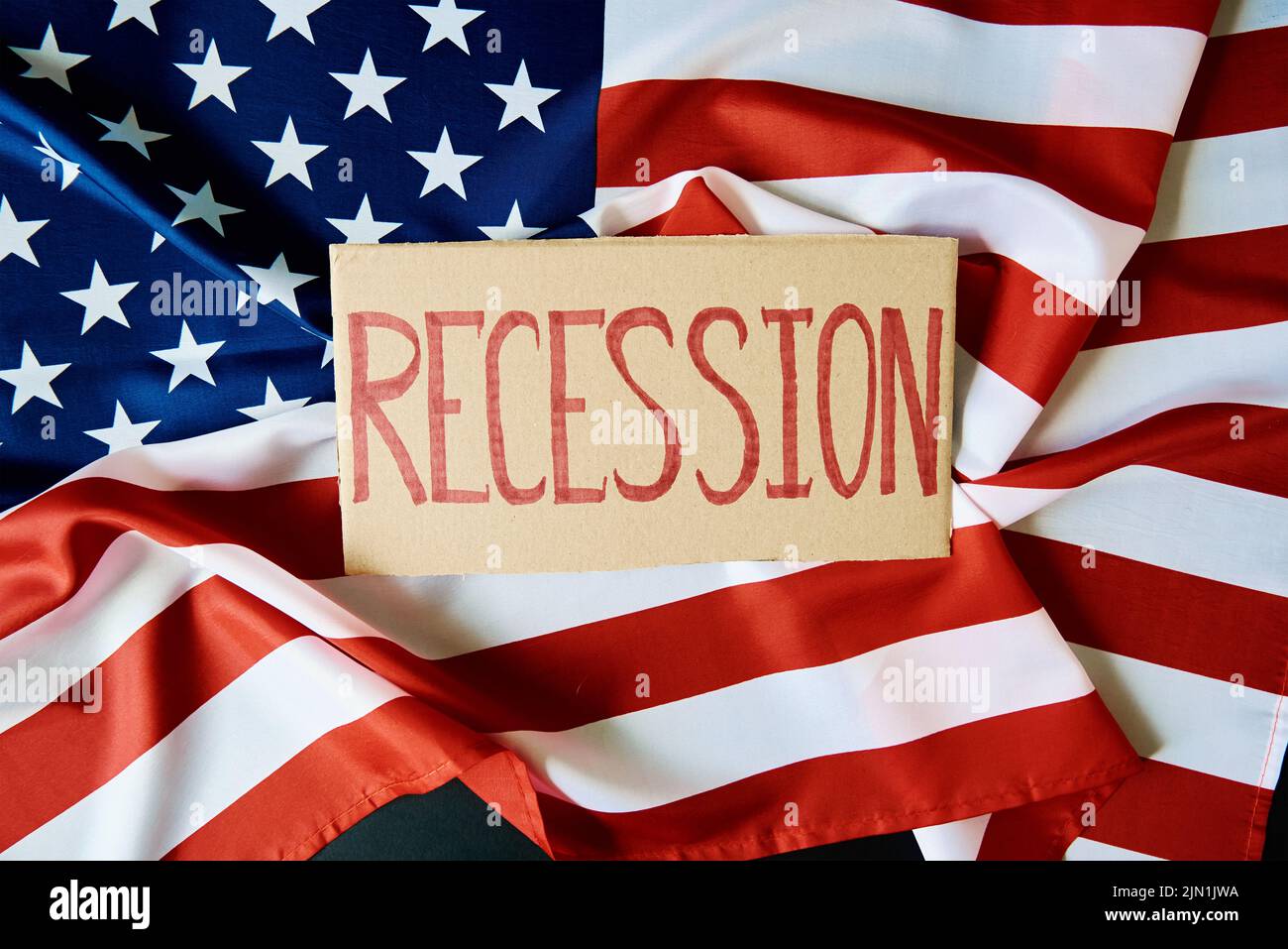 Concept of recession and financial problem in USA banking system and world economic crisis,Cardboard with word recession against national american fla Stock Photo