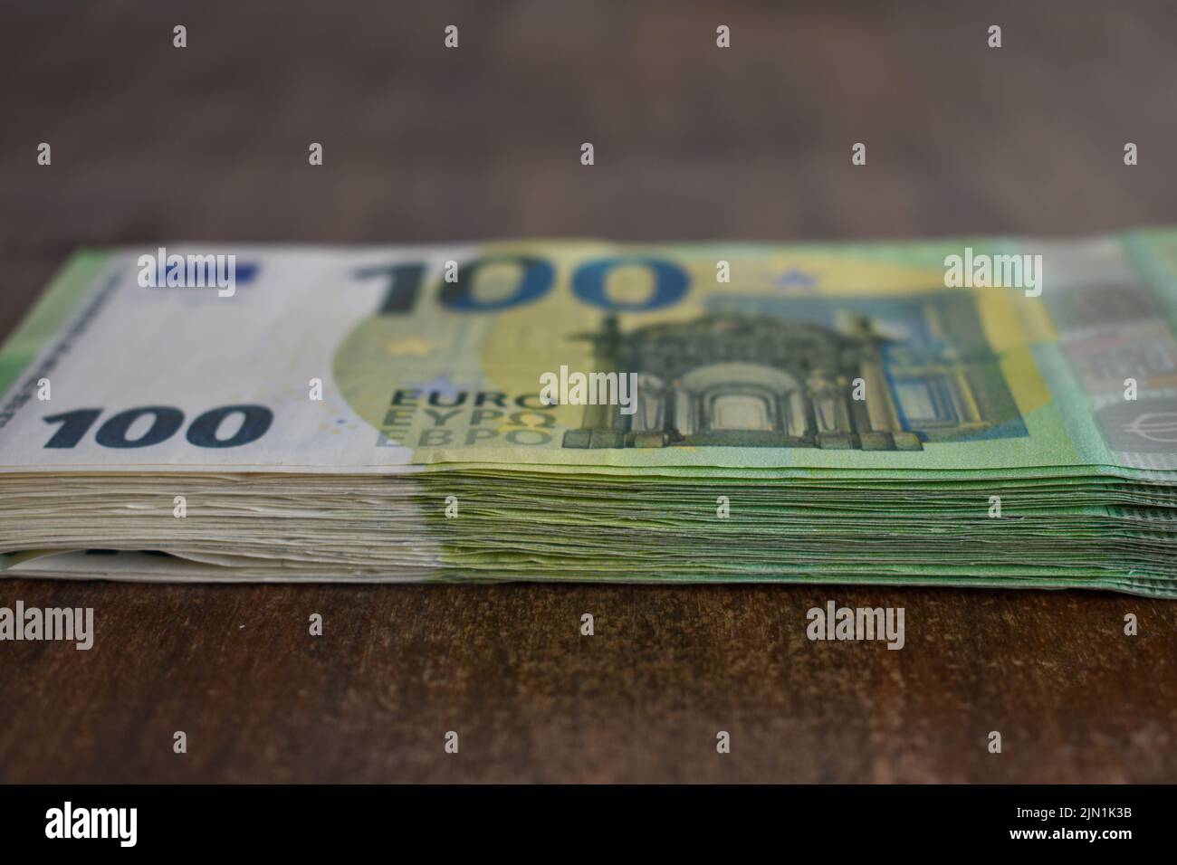 pile of 100 Euro bank notes on a table Stock Photo - Alamy