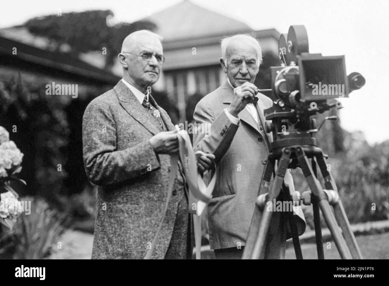 George Eastman (left) and Thomas Edison in July 1928, with motion picture camera at Eastman's house in Rochester, New York, where a demonstration of the new Kodacolor film was being held. (USA) Stock Photo