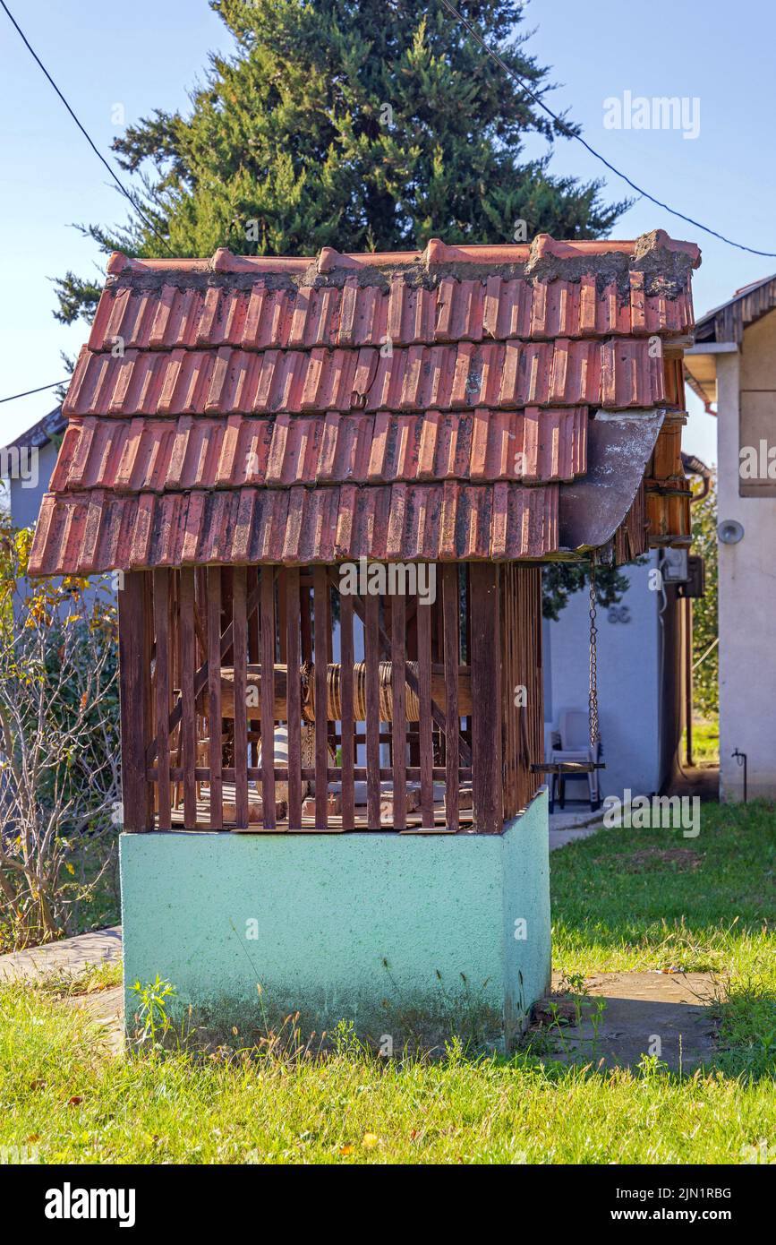 Water Well in Wooden Enclosure With Roof in Village Stock Photo