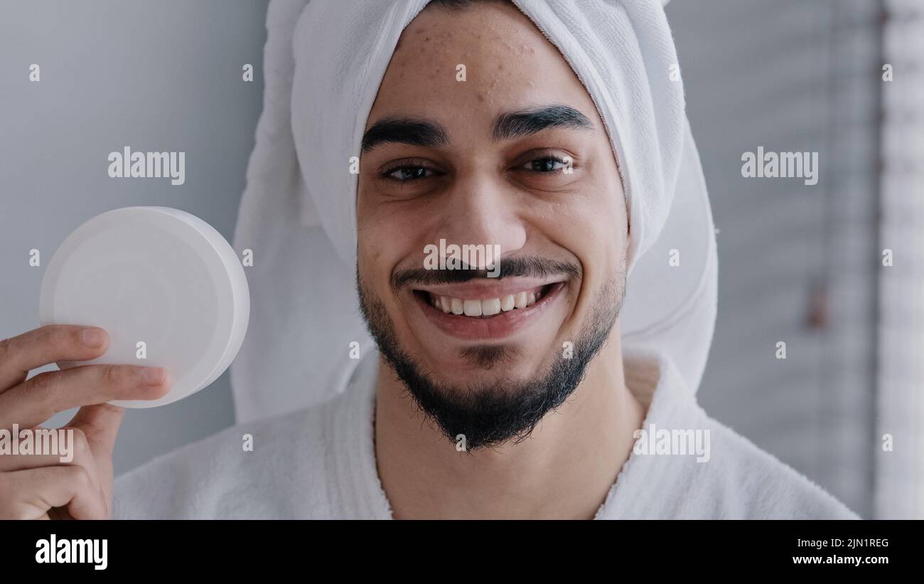 https://c8.alamy.com/comp/2JN1REG/arabian-hispanic-indian-man-with-towel-on-head-holding-jar-of-cream-for-face-laugh-looking-at-camera-recommend-natural-male-cosmetic-in-bathroom-2JN1REG.jpg