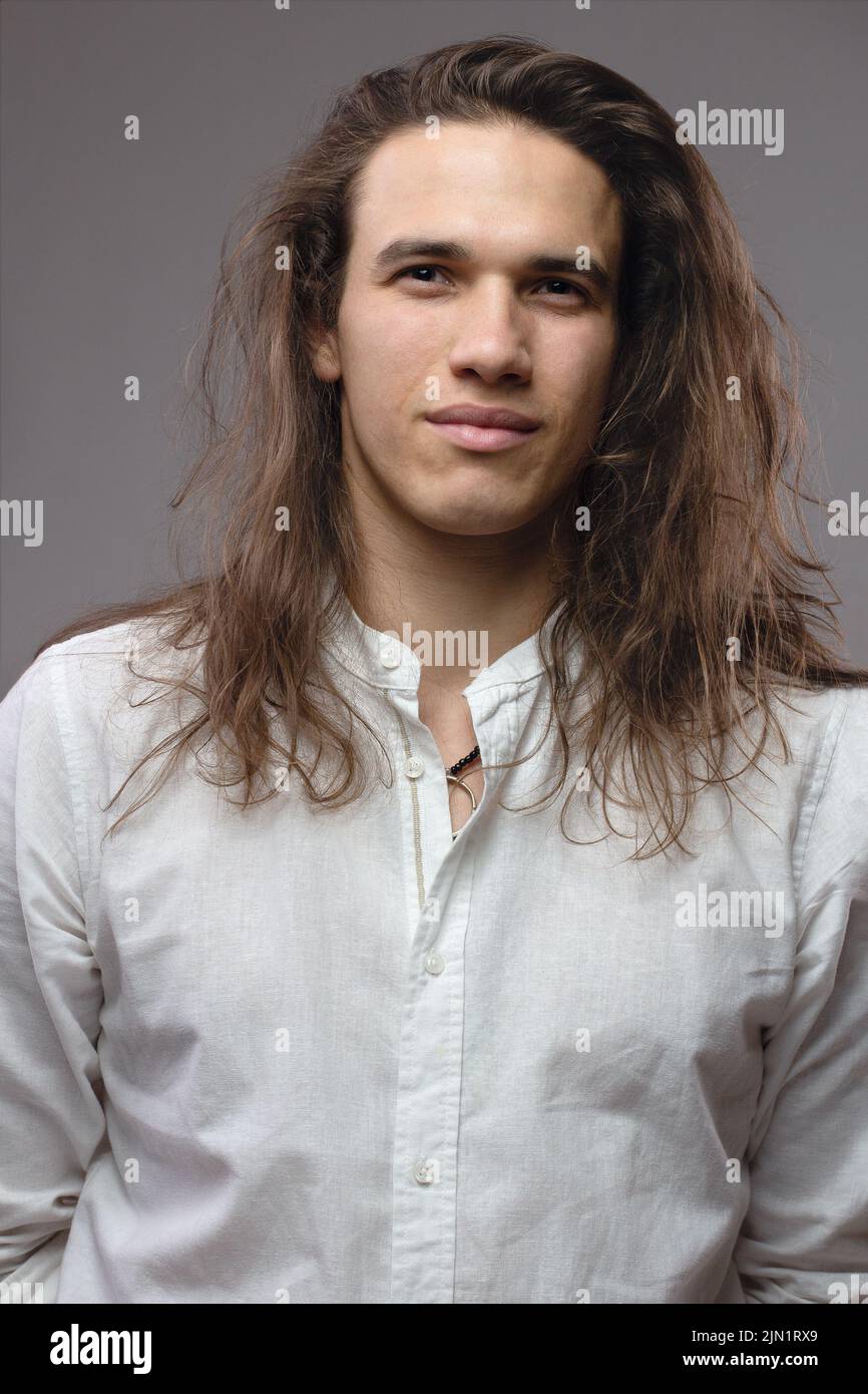 Handsome calm man. Portrait of a young muscular guy with long hair