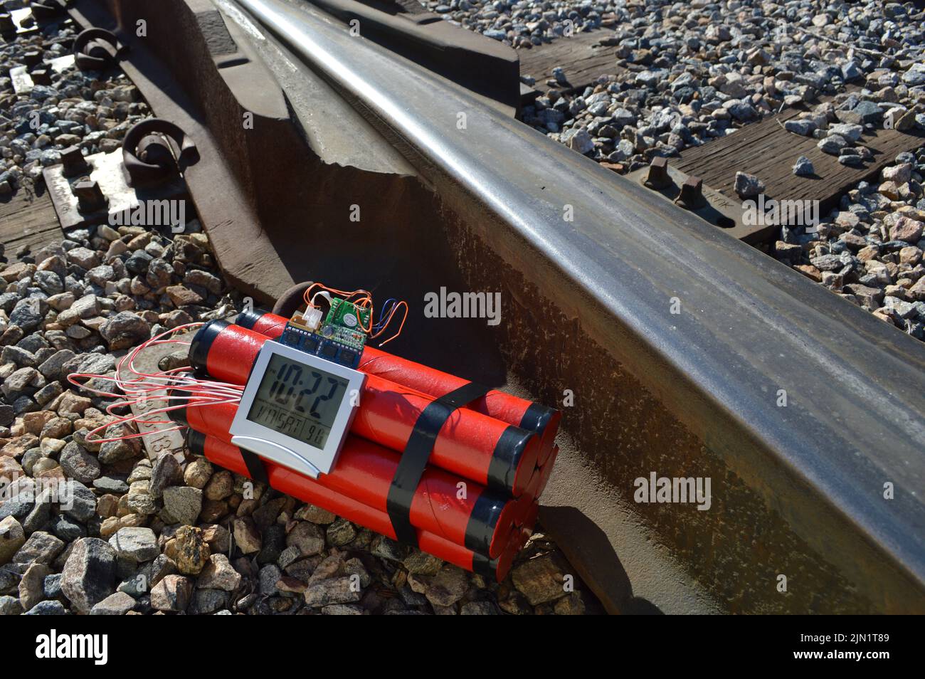 Time bomb made of dynamite, on railroad tracks Stock Photo